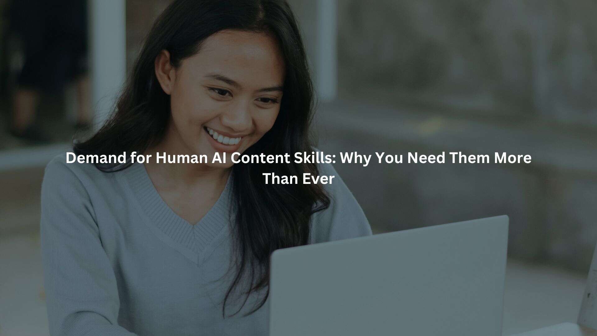 a young woman with long dark hair smiling while using a laptop. The text overlay reads "Demand for Human AI Content Skills: Why You Need Them More Than Ever".