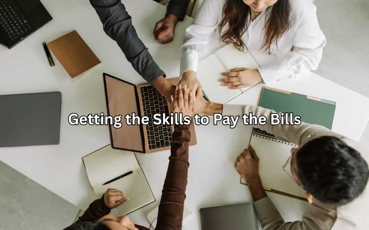 The image shows a group of people collaborating around a desk, suggesting the importance of teamwork and skills development for career success.